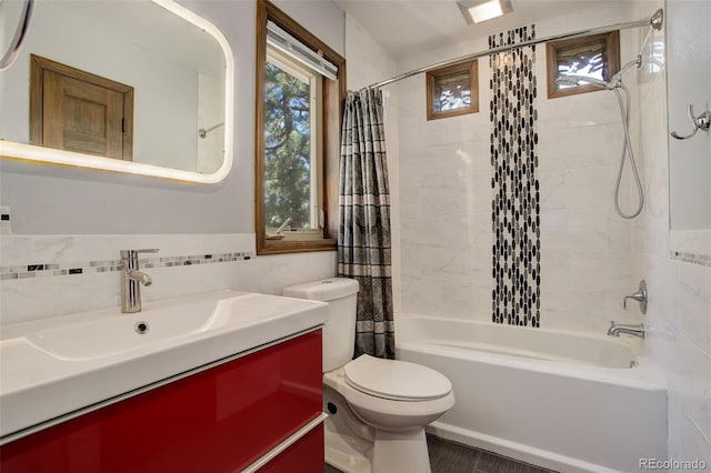 full bathroom with shower / bath combo with shower curtain, vanity, tile walls, and toilet