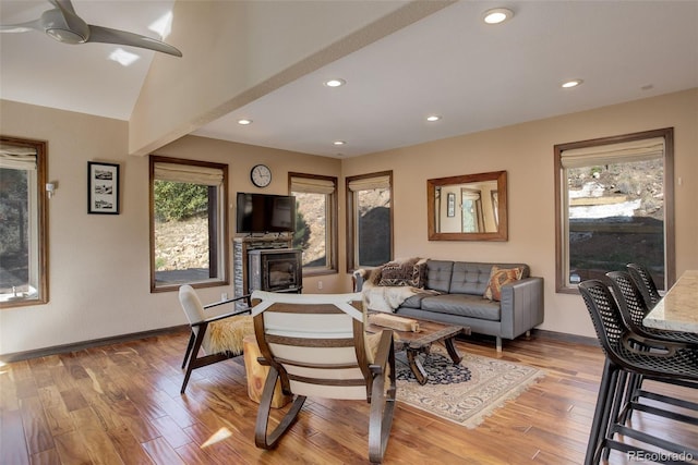 living room with ceiling fan, light hardwood / wood-style floors, and lofted ceiling