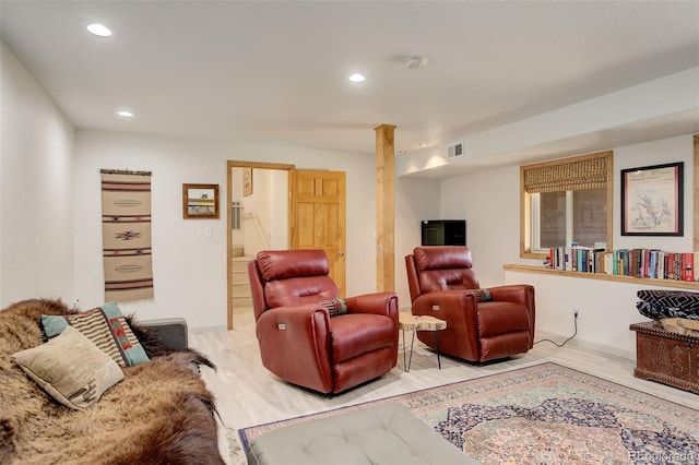 living room featuring decorative columns and light hardwood / wood-style flooring