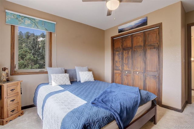 bedroom featuring ceiling fan, light colored carpet, and a closet