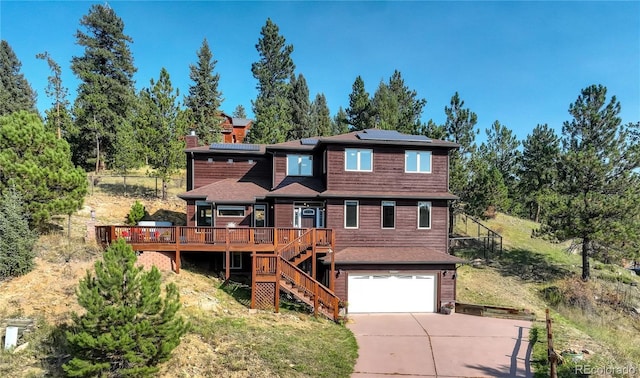 view of front of property with a wooden deck, a garage, and solar panels