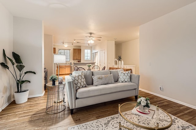 14700 E 104th Ave Unit 2802, Commerce City, CO 80022 - living room with light wood-type flooring, ceiling fan, and baseboards