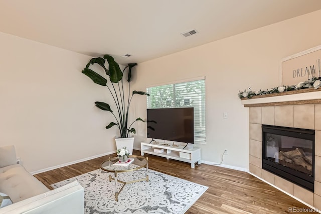 14700 E 104th Ave Unit 2802, Commerce City, CO 80022 - living area with wood finished floors, a tile fireplace, and baseboards