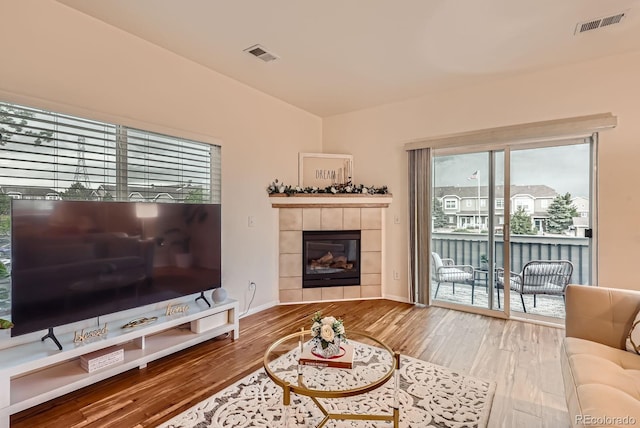 14700 E 104th Ave Unit 2802, Commerce City, CO 80022 - living area featuring wood finished floors, a tiled fireplace, and baseboards