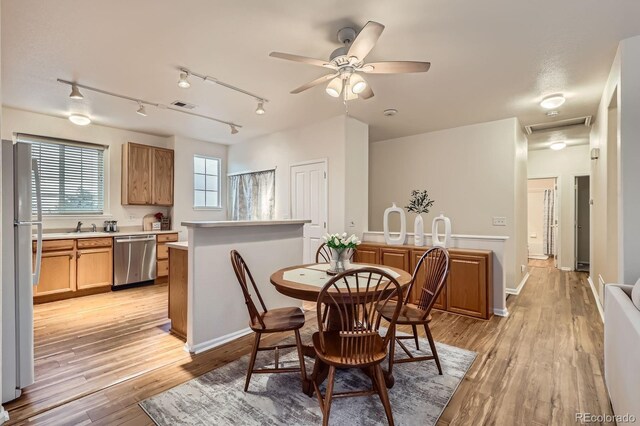 14700 E 104th Ave Unit 2802, Commerce City, CO 80022 - dining space with track lighting, light wood-type flooring, a ceiling fan, and baseboards