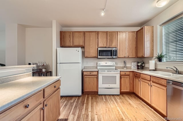 14700 E 104th Ave Unit 2802, Commerce City, CO 80022 - kitchen with appliances with stainless steel finishes, a sink, light wood-style flooring, light countertops, and track lighting