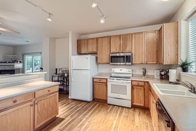 14700 E 104th Ave Unit 2802, Commerce City, CO 80022 - kitchen featuring white appliances, a sink, rail lighting, and light countertops