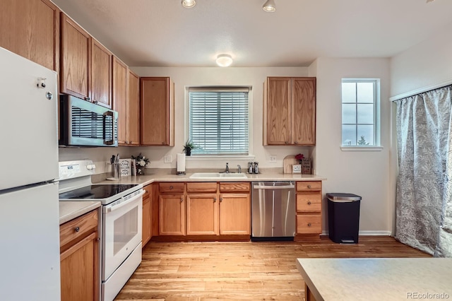 14700 E 104th Ave Unit 2802, Commerce City, CO 80022 - kitchen featuring stainless steel appliances, a sink, light countertops, and light wood-style flooring