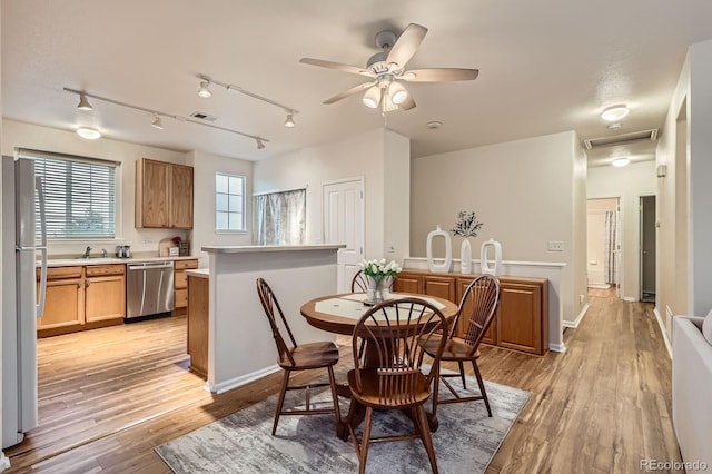 14700 E 104th Ave Unit 2802, Commerce City, CO 80022 - dining space featuring light wood-style flooring, track lighting, and a ceiling fan