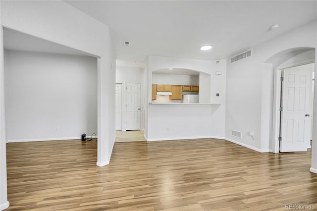 5255 Memphis St Unit 317, Denver, CO 80239 - unfurnished living room featuring light wood-style flooring, recessed lighting, and arched walkways