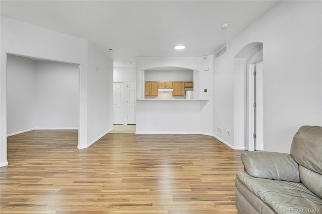 5255 Memphis St Unit 317, Denver, CO 80239 - living room featuring arched walkways, light wood finished floors, and recessed lighting