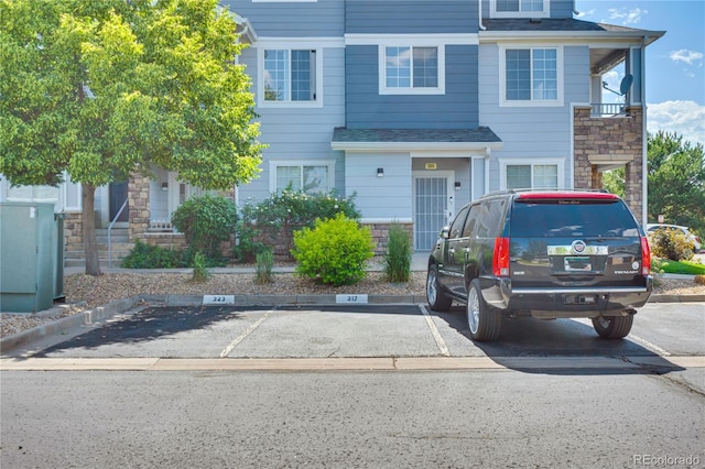 5255 Memphis St Unit 317, Denver, CO 80239 - view of property with stone siding and uncovered parking