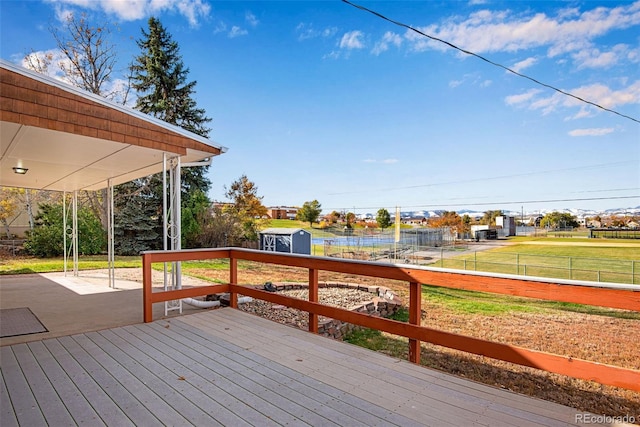 deck featuring a storage shed, fence, and an outdoor structure