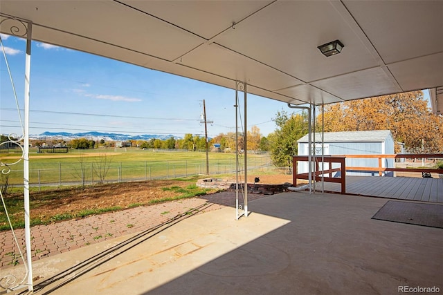 view of patio / terrace with a deck with mountain view and a fenced backyard