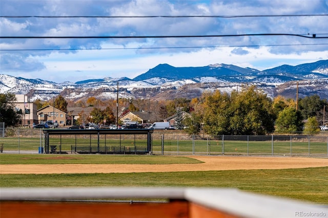 view of home's community with a yard, a mountain view, and fence