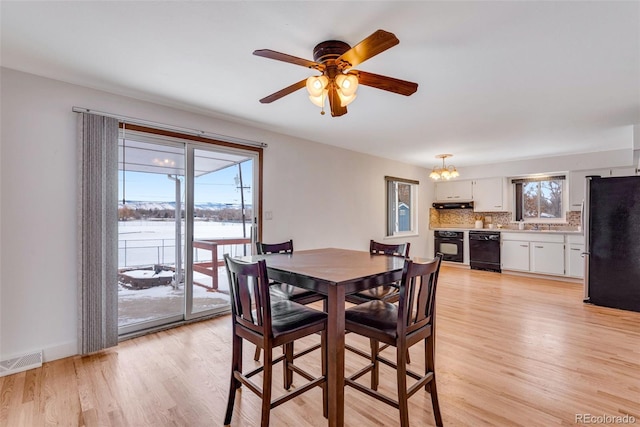 dining room with light wood-type flooring, baseboards, visible vents, and a wealth of natural light