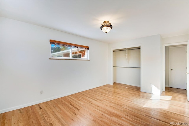 unfurnished bedroom with light wood-type flooring, baseboards, and a closet