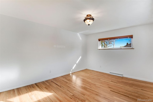 empty room featuring baseboards, visible vents, and light wood finished floors