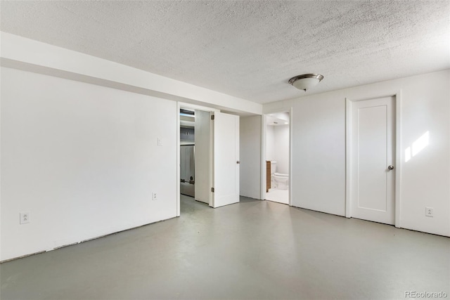 unfurnished room featuring finished concrete floors and a textured ceiling