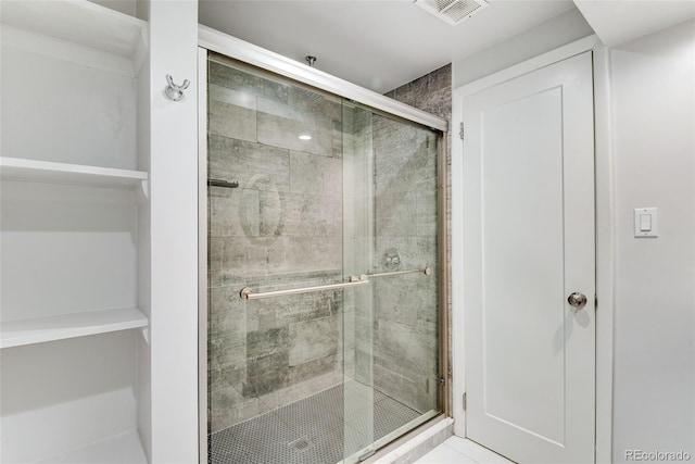 bathroom with a shower stall and visible vents