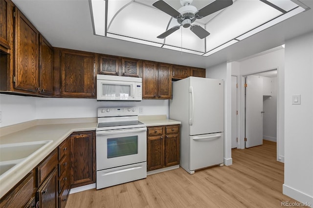 kitchen featuring light countertops, ceiling fan, white appliances, and light wood-style flooring