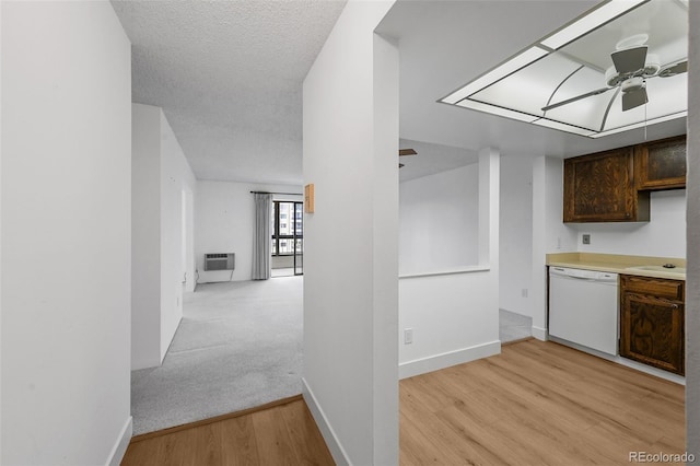 kitchen with ceiling fan, dark brown cabinetry, a wall unit AC, white dishwasher, and light wood-type flooring