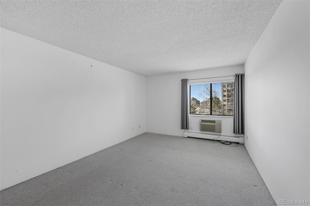 carpeted empty room with a baseboard heating unit and a textured ceiling