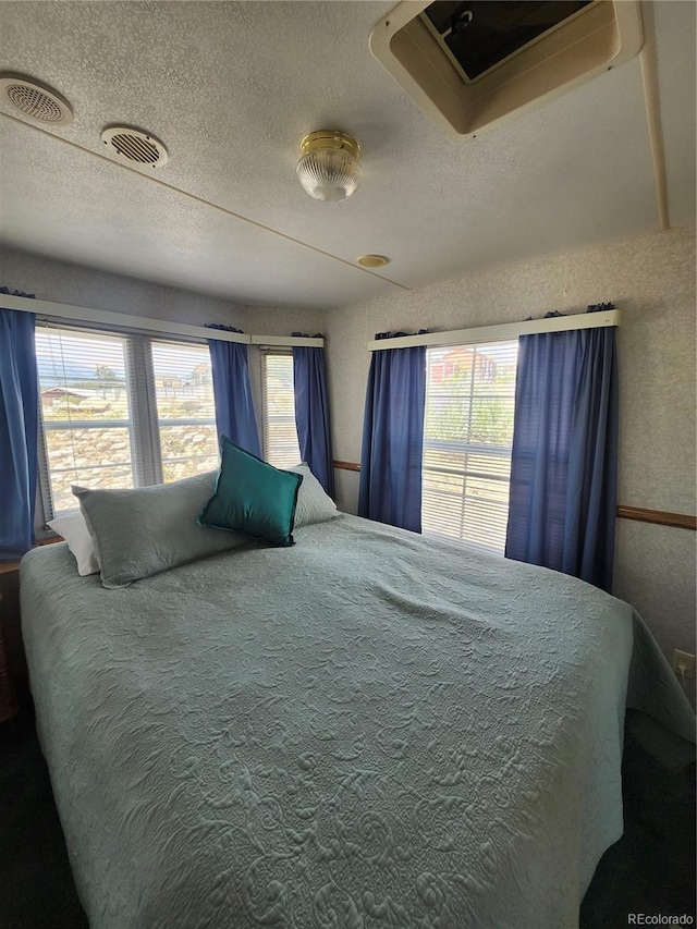 bedroom with carpet floors and a textured ceiling