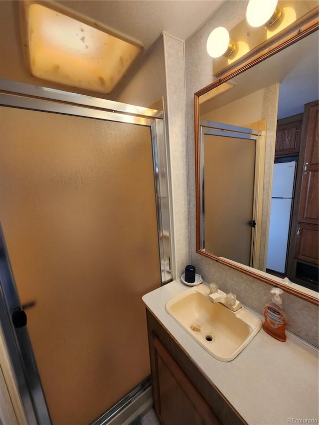 bathroom with vanity and a shower with shower door