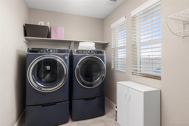 laundry room featuring light tile patterned flooring and washing machine and dryer