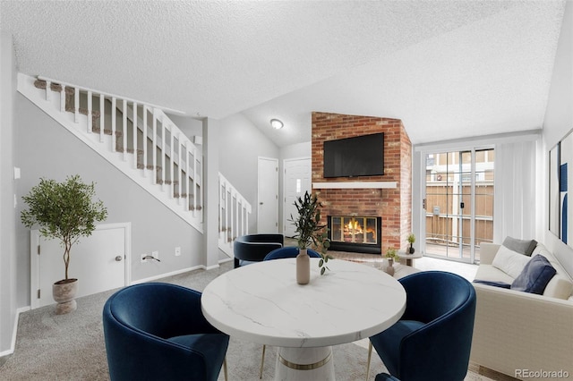 14343 E Dickinson Dr Unit E, Aurora, CO 80014 - carpeted dining space with a fireplace, baseboards, stairway, a textured ceiling, and vaulted ceiling