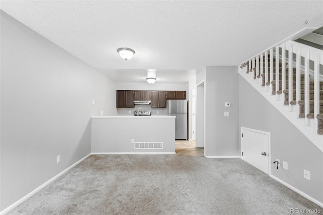 14343 E Dickinson Dr Unit E, Aurora, CO 80014 - unfurnished living room featuring visible vents, stairs, light carpet, baseboards, and a textured ceiling