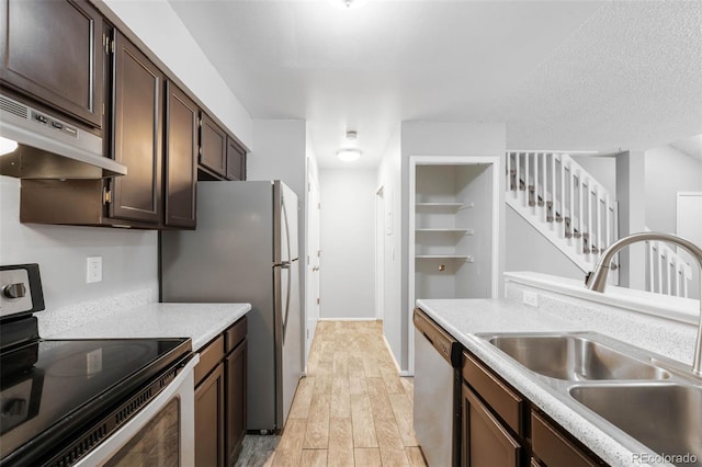 14343 E Dickinson Dr Unit E, Aurora, CO 80014 - kitchen featuring dark brown cabinetry, appliances with stainless steel finishes, a sink, light wood finished floors, and under cabinet range hood