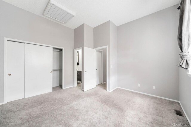 14343 E Dickinson Dr Unit E, Aurora, CO 80014 - unfurnished bedroom featuring a closet, baseboards, light colored carpet, and visible vents