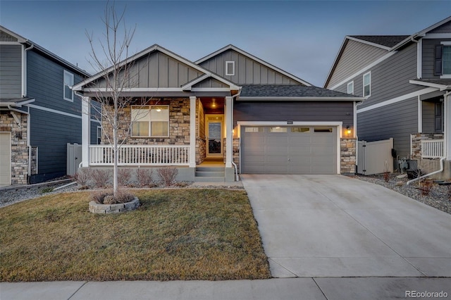 view of front of property featuring a porch, a garage, and a front yard