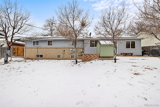 view of snow covered back of property