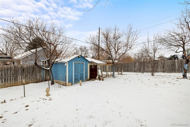 yard covered in snow with a storage shed