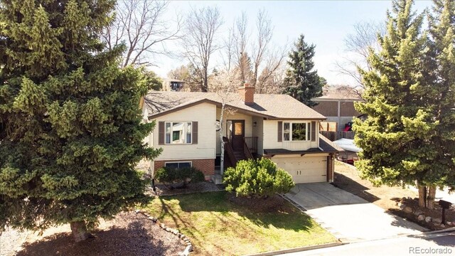 8210 W 72nd Pl, Arvada, CO 80005 - view of front of house with driveway, a garage, and a chimney