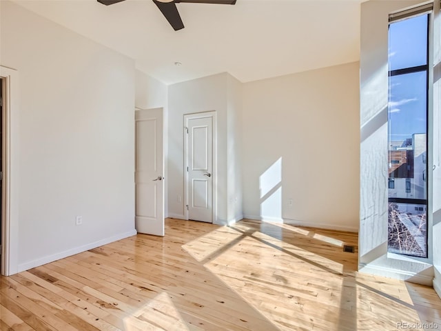 empty room with light wood-type flooring and ceiling fan