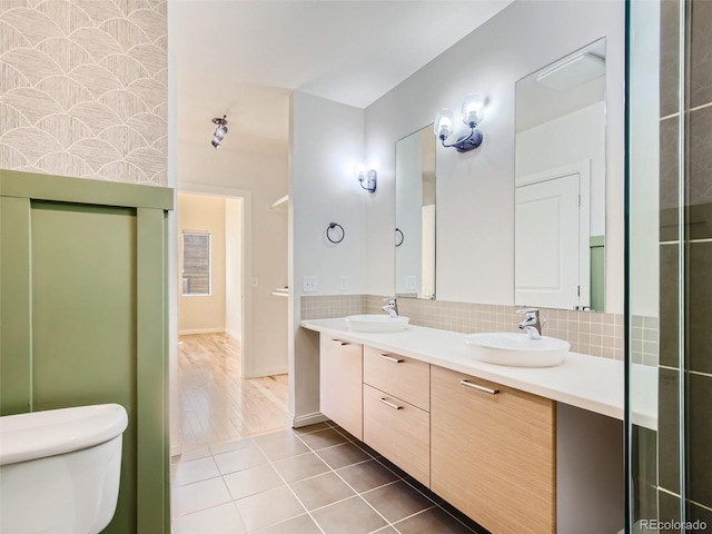 bathroom featuring toilet, vanity, tasteful backsplash, and tile patterned flooring