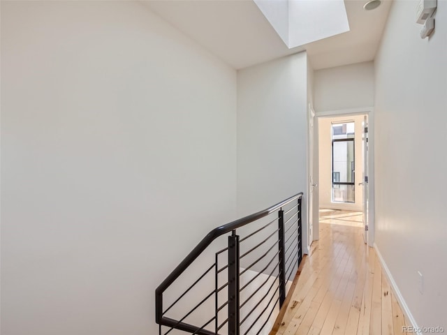 corridor featuring light hardwood / wood-style flooring and a skylight