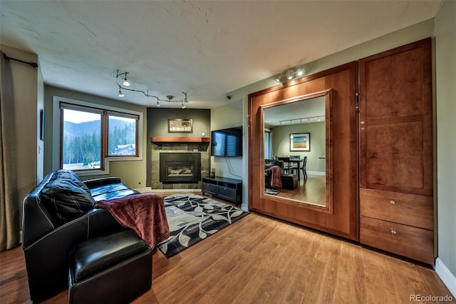 310 Iron Horse Way Unit D5034, Winter Park, CO 80482 - living room with wood finished floors, a tiled fireplace, and rail lighting