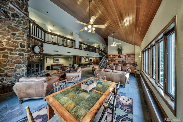 310 Iron Horse Way Unit D5034, Winter Park, CO 80482 - dining room featuring wooden ceiling, a ceiling fan, a fireplace, stone tile floors, and high vaulted ceiling