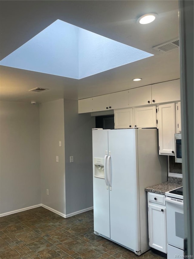 2617 S Cimarron St, Aurora, CO 80014 - kitchen with white appliances, dark stone finish flooring, white cabinetry, baseboards, and recessed lighting