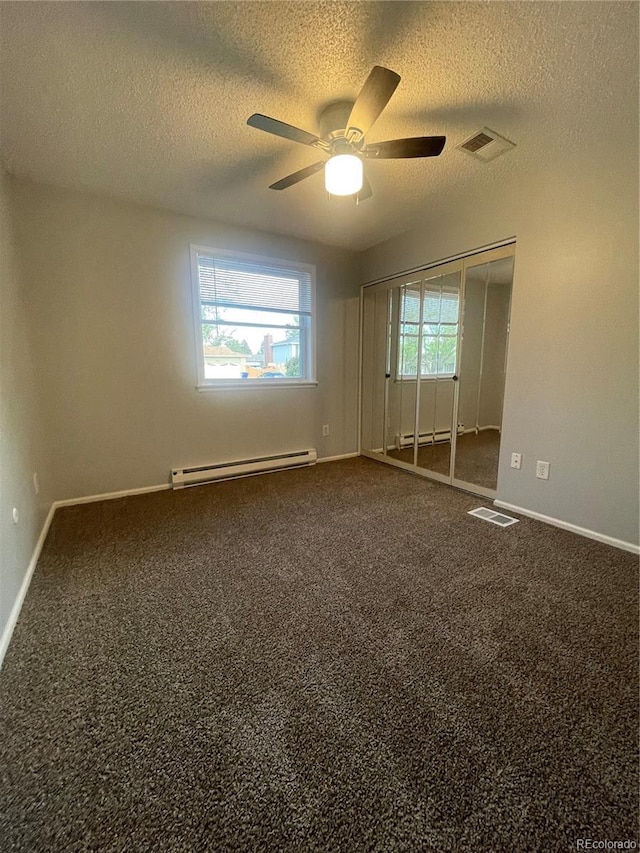 2617 S Cimarron St, Aurora, CO 80014 - unfurnished bedroom with a baseboard radiator, a textured ceiling, baseboards, and dark colored carpet