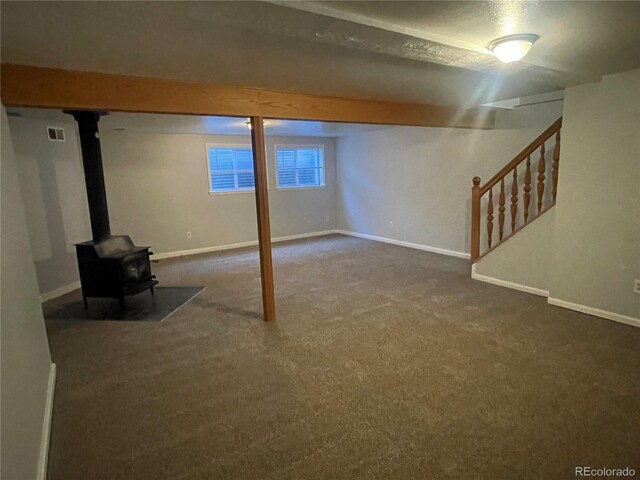 2617 S Cimarron St, Aurora, CO 80014 - below grade area featuring carpet floors, stairway, baseboards, and a wood stove