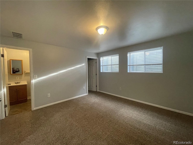 2617 S Cimarron St, Aurora, CO 80014 - empty room featuring baseboards, dark colored carpet, and a sink