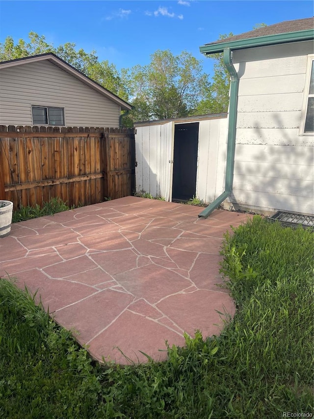 2617 S Cimarron St, Aurora, CO 80014 - view of patio / terrace with a storage shed, an outbuilding, and fence