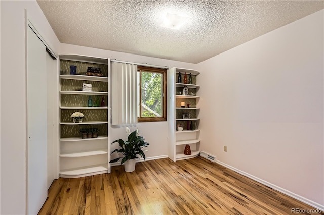 10247 W Arkansas Ave, Lakewood, CO 80232 - spare room featuring wood finished floors, a textured ceiling, and baseboards