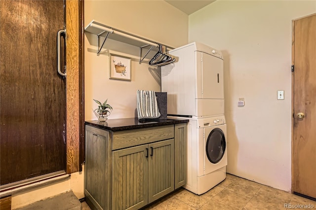 10247 W Arkansas Ave, Lakewood, CO 80232 - clothes washing area featuring stacked washing machine and dryer, cabinet space, and light tile patterned floors